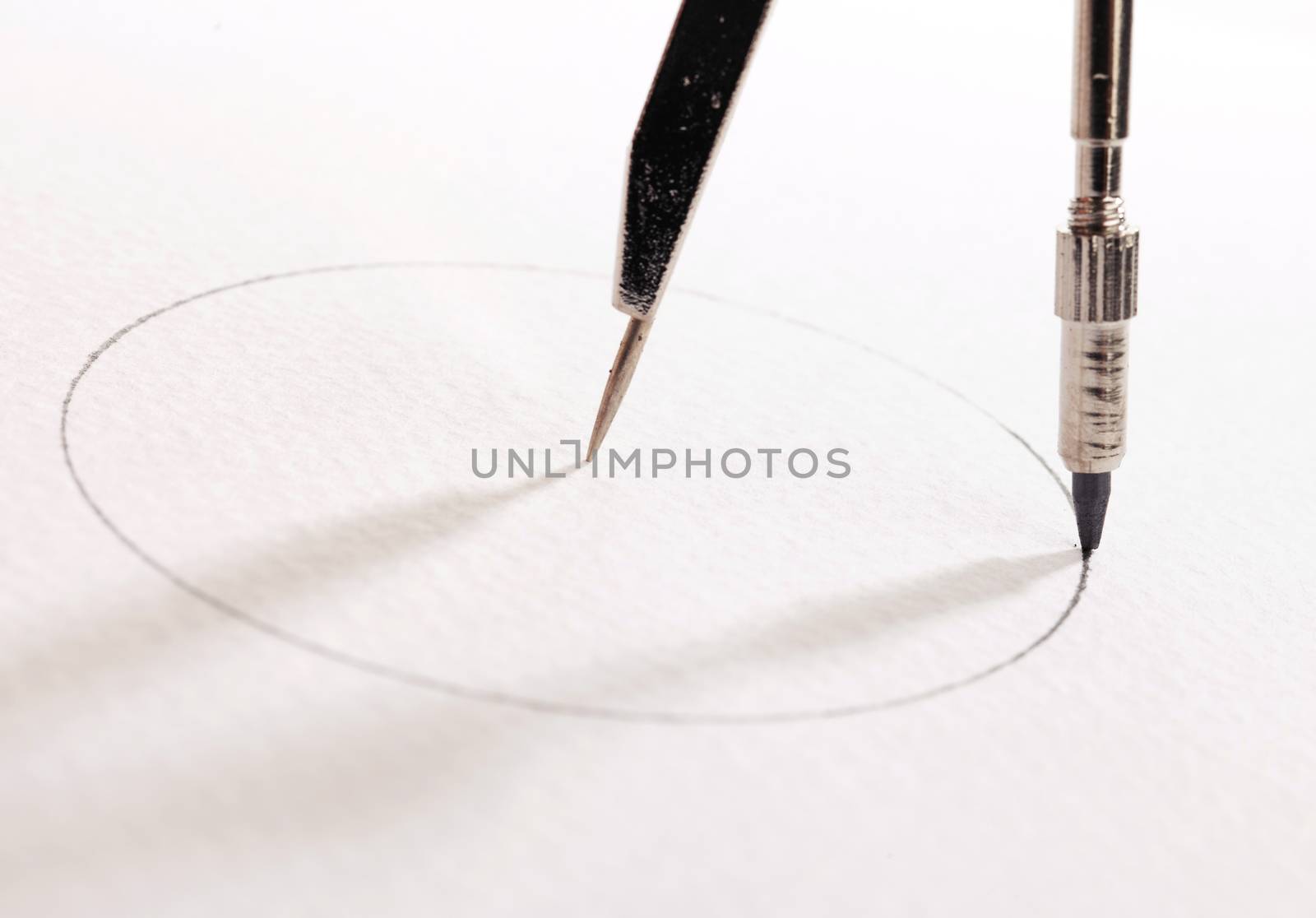 pair of compasses drawing circle on a paper