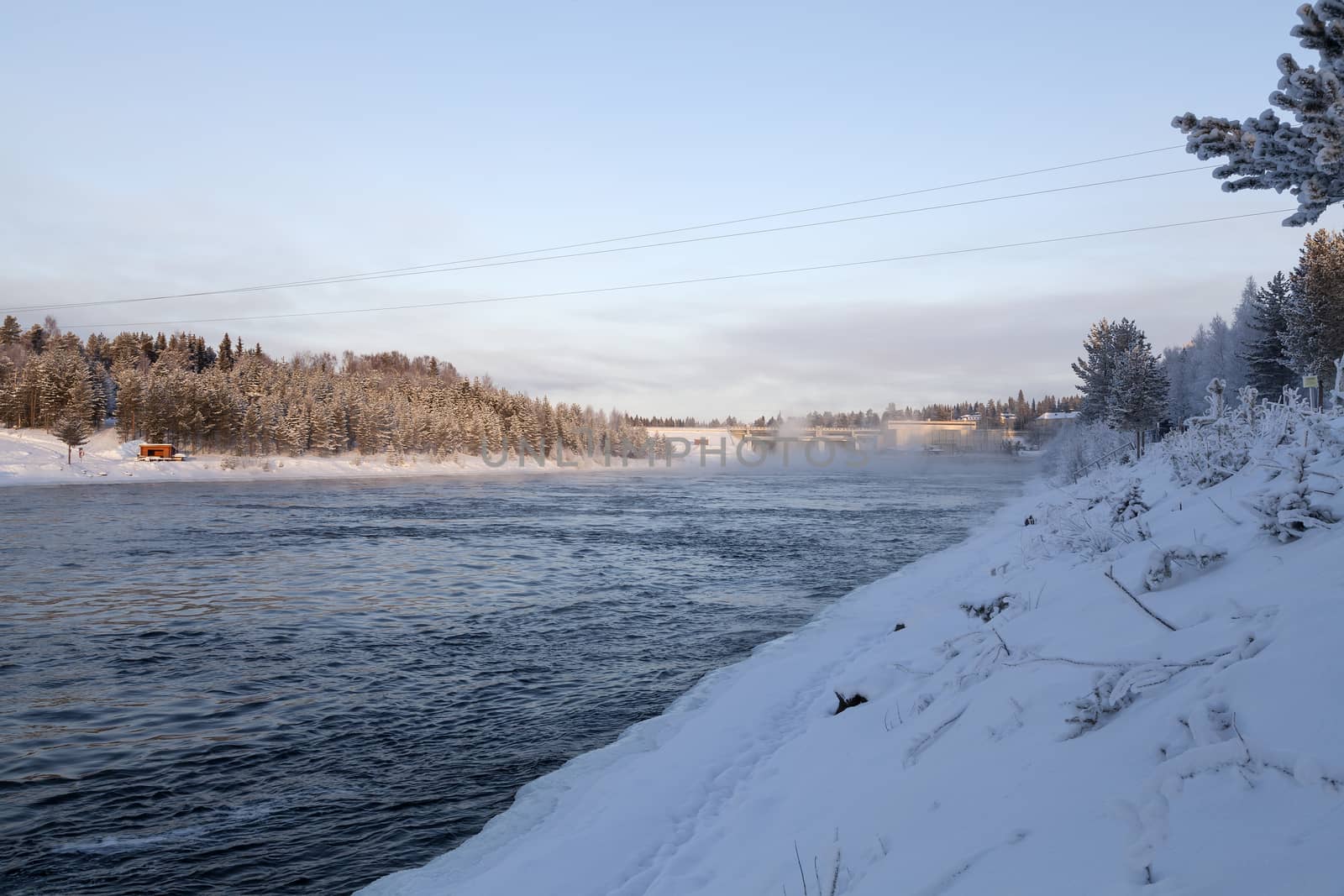 A water driven power plant in the winter with some mist from the water