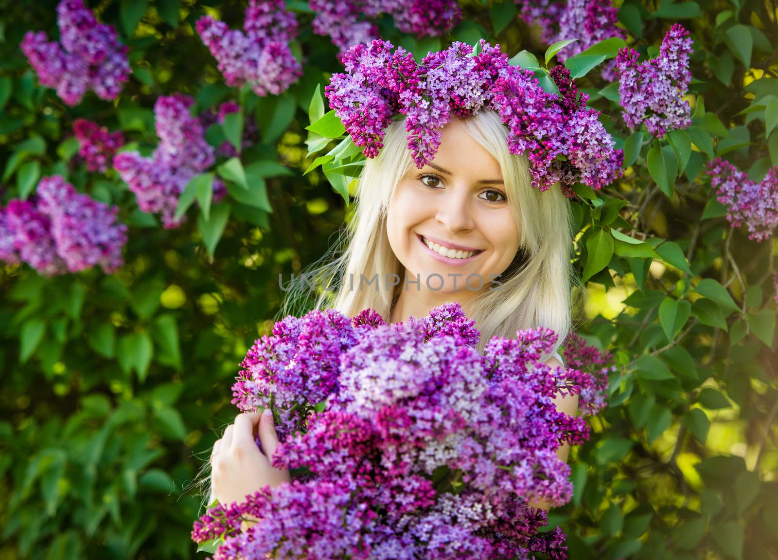 Beautiful smiling young woman is wearing wreath of lilac flowers by Draw05