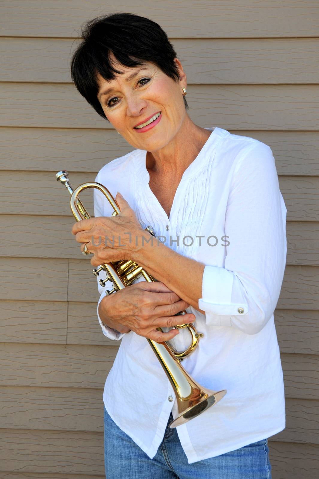 Mature female beauty blowing her trumpet outside.