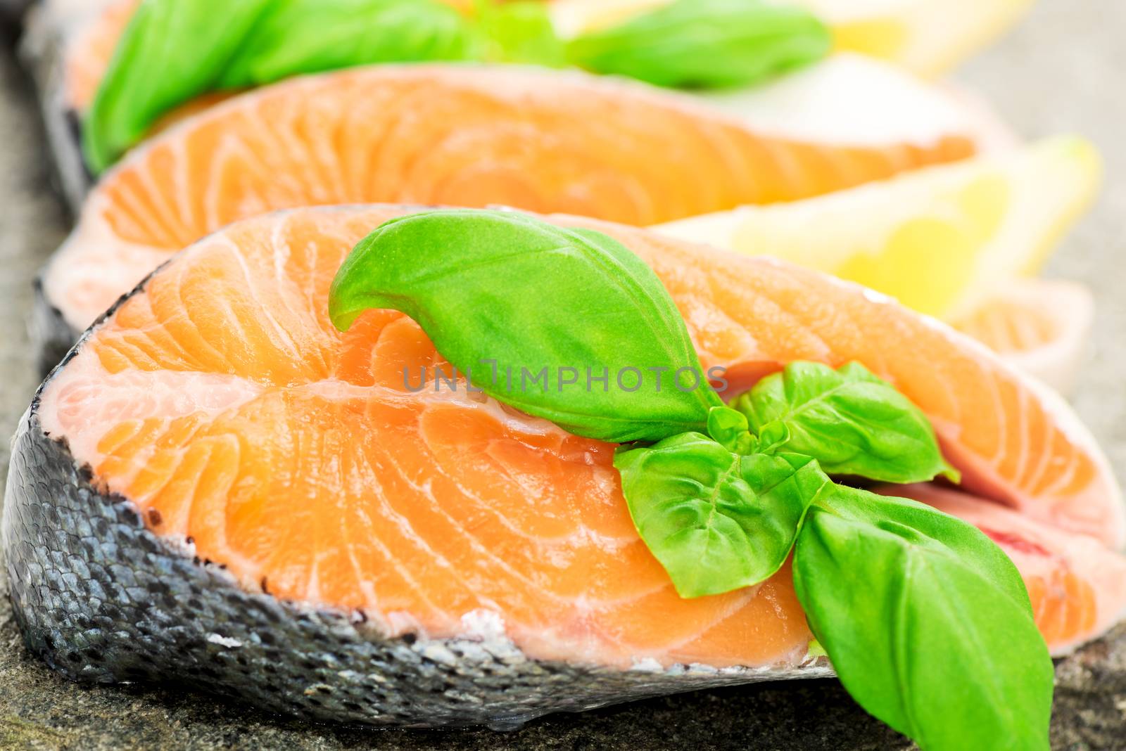 Salmon on stone with basil and lemon macro by Nanisimova