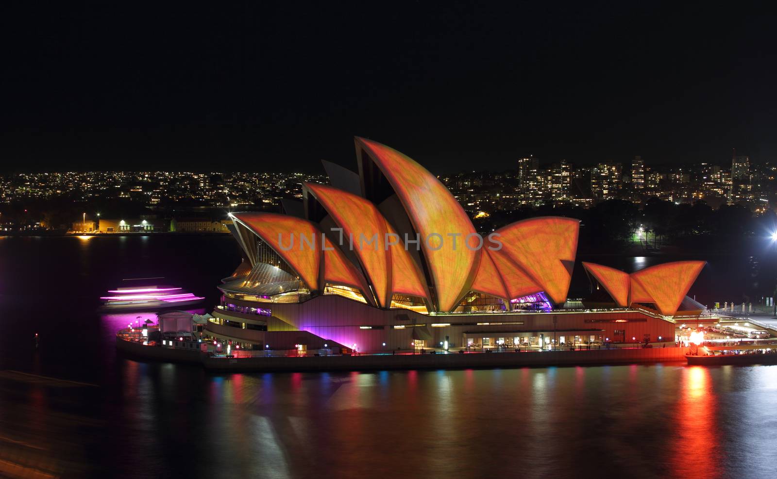 SYDNEY, AUSTRALIA - MAY 27, 2015; The Sydney Opera House comes alive each night during Vivid Sydney.  Coloured lights and patterns shine on the roof creating a spectacular event.  Here the roof alight in vivid orange and yellow from a 20 second exposure of various imagey