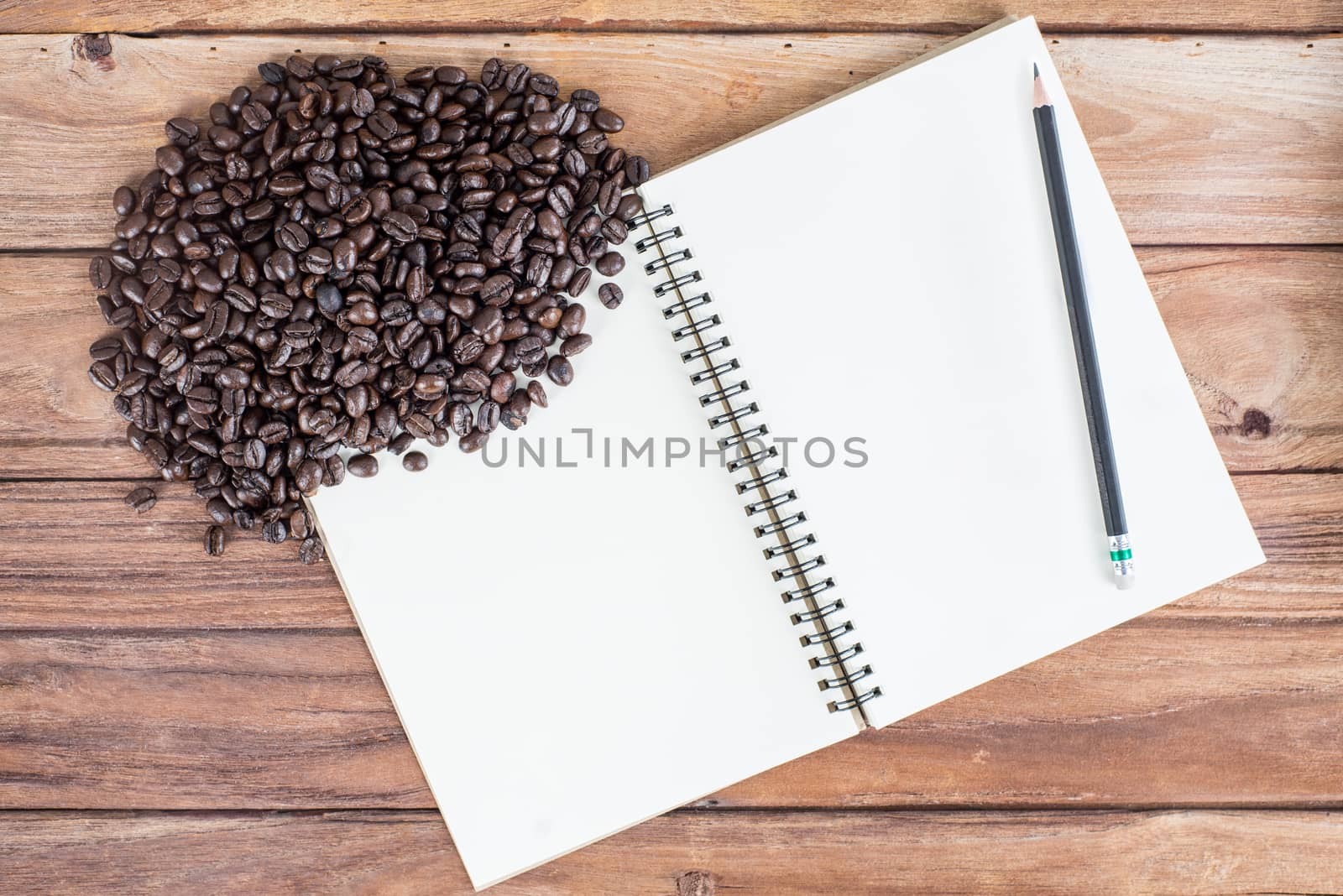 Pencil, notebook, coffee bean on wooden background by iamway
