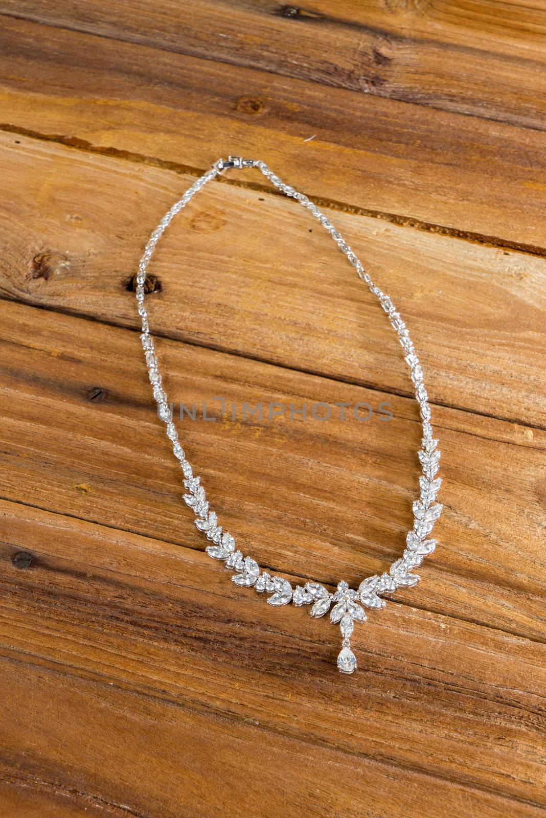 Diamond necklace on wooden background by iamway