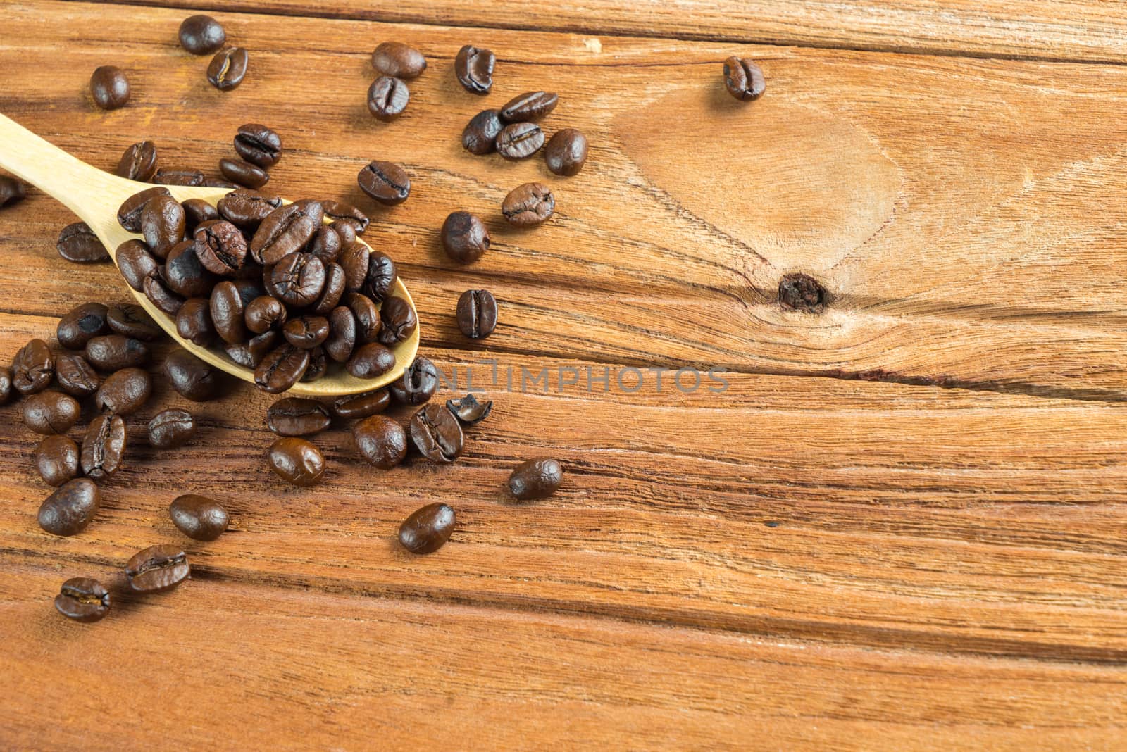 Coffee bean on wooden spoon, wooden table background by iamway