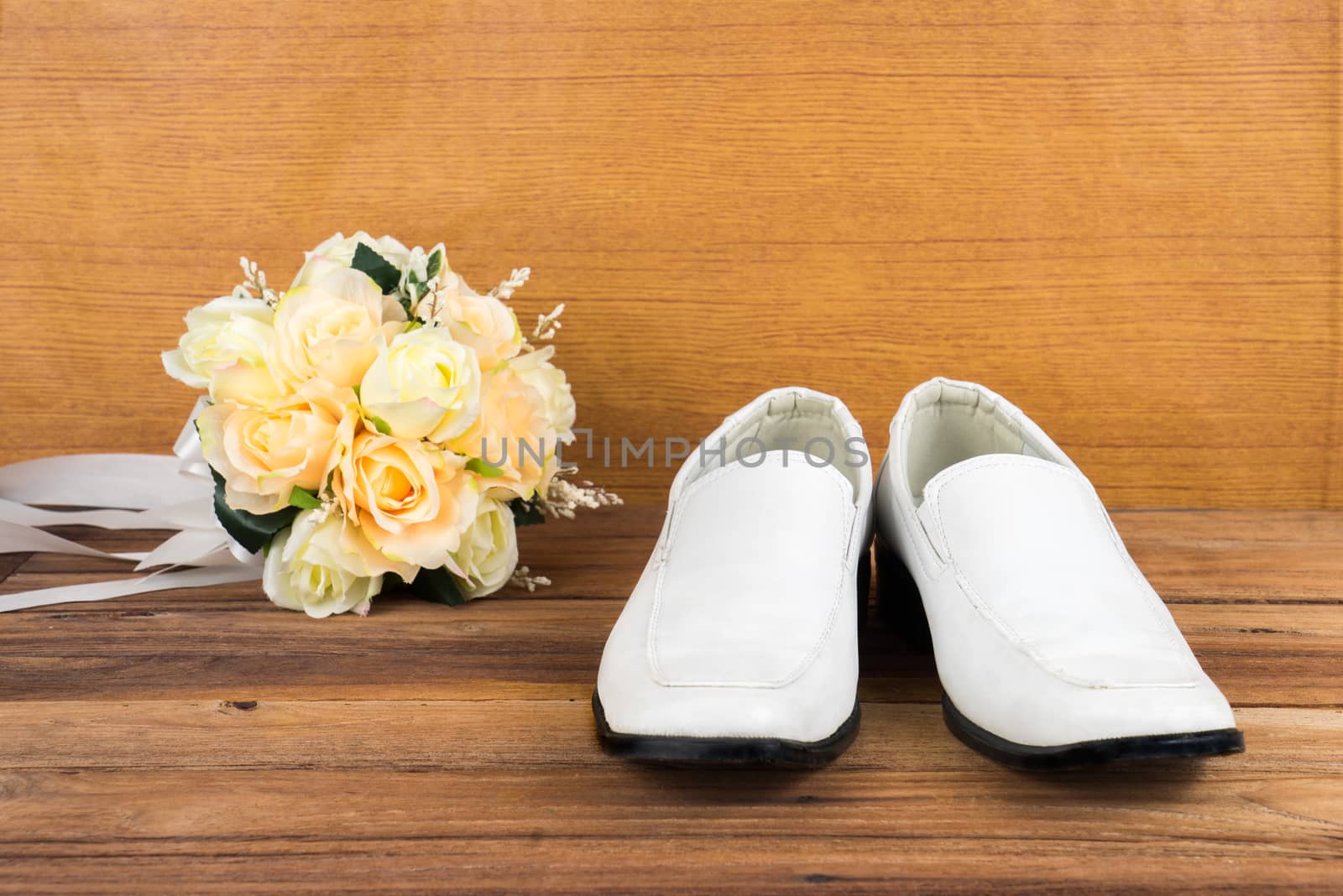 Wedding bouquet with groom's shoes on wood background by iamway