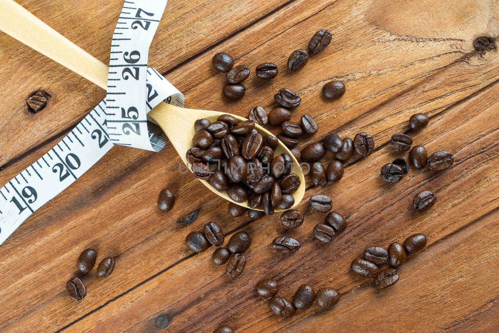 Coffee bean on wooden spoon, tape measure on wooden background by iamway