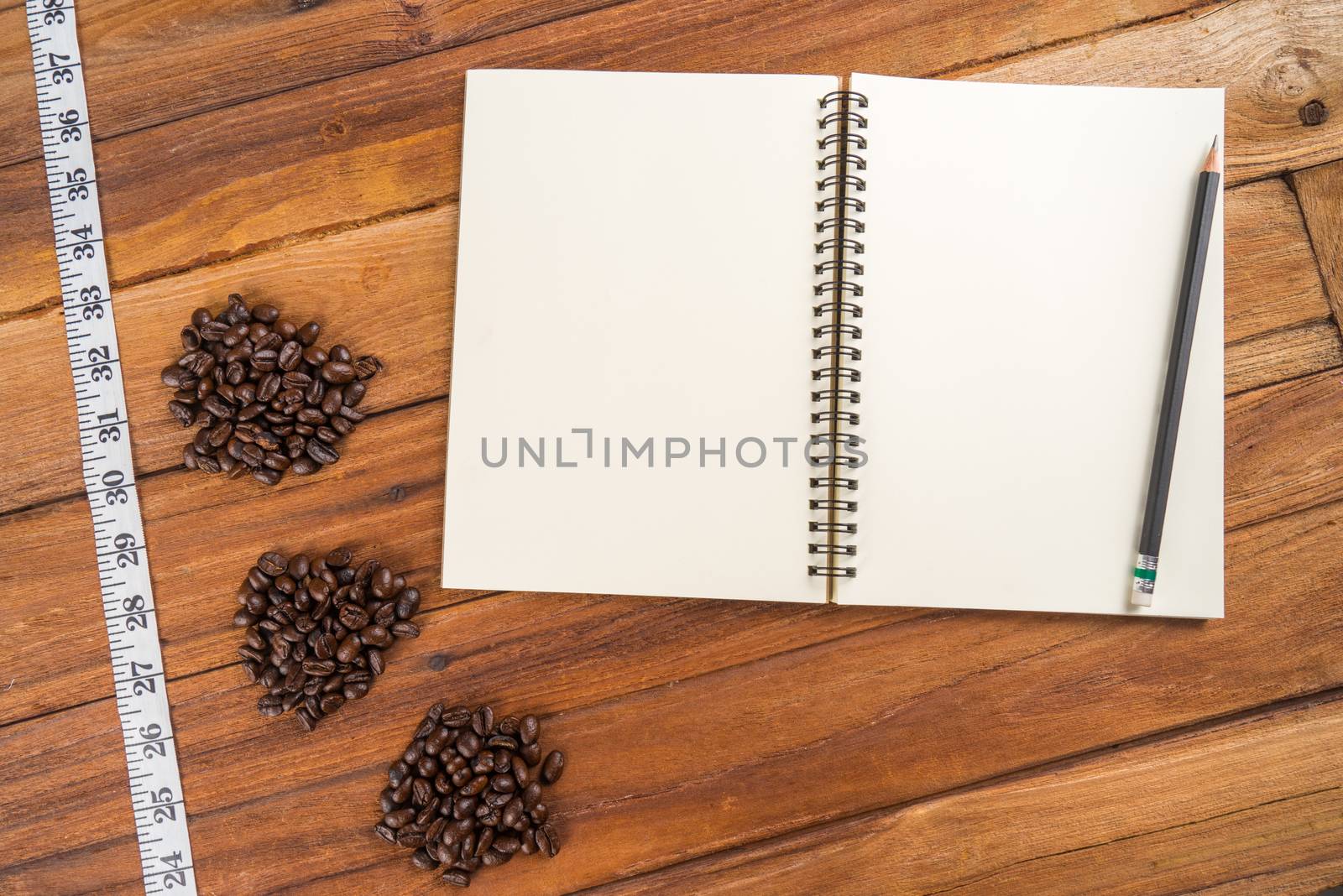 Wooden Clipboard attach planning paper with pencil on top beside coffee bean, tape measure
