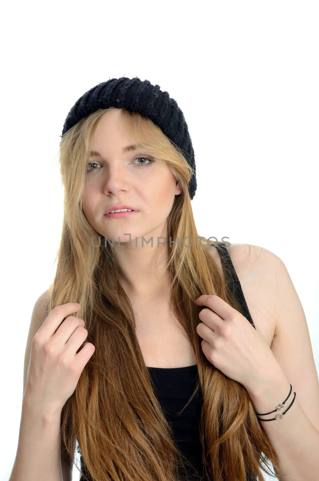 Elegant female model with kind face expression. Young girl with blond hairs and black hat.