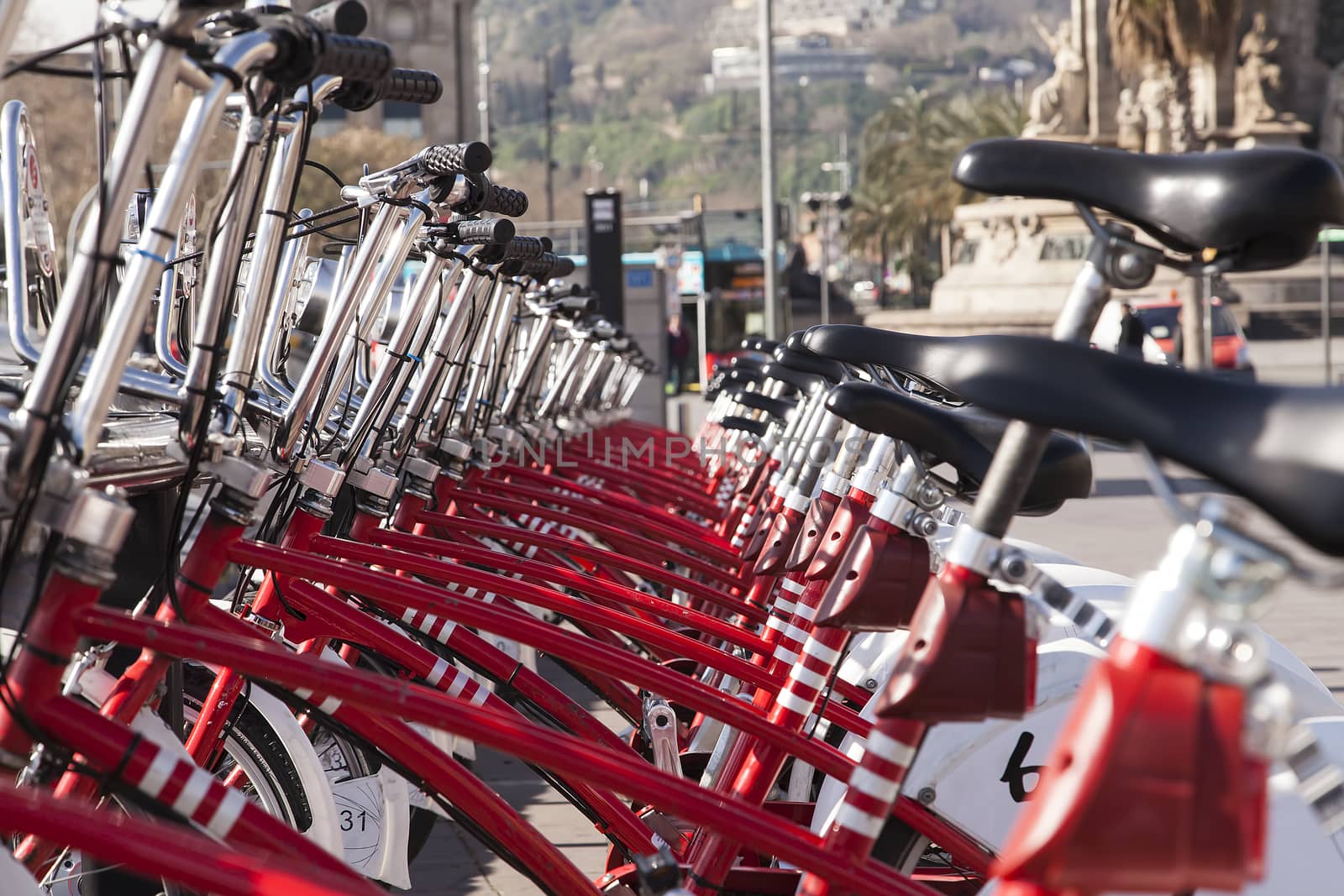 A set of red bikes and a city in the background