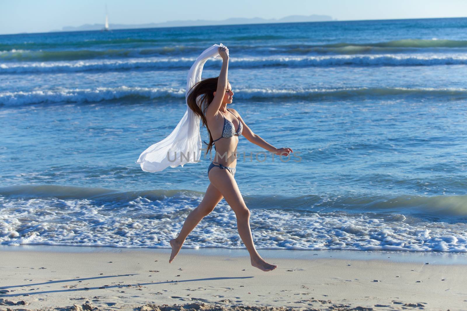 young woman jumping on the beach