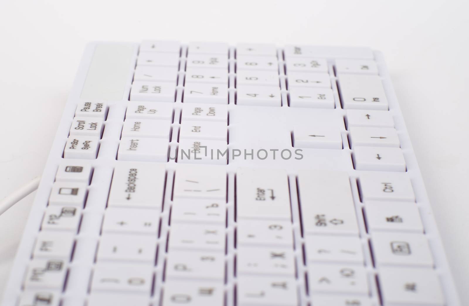 Computer keyboard with wire on isolated white background, close up view