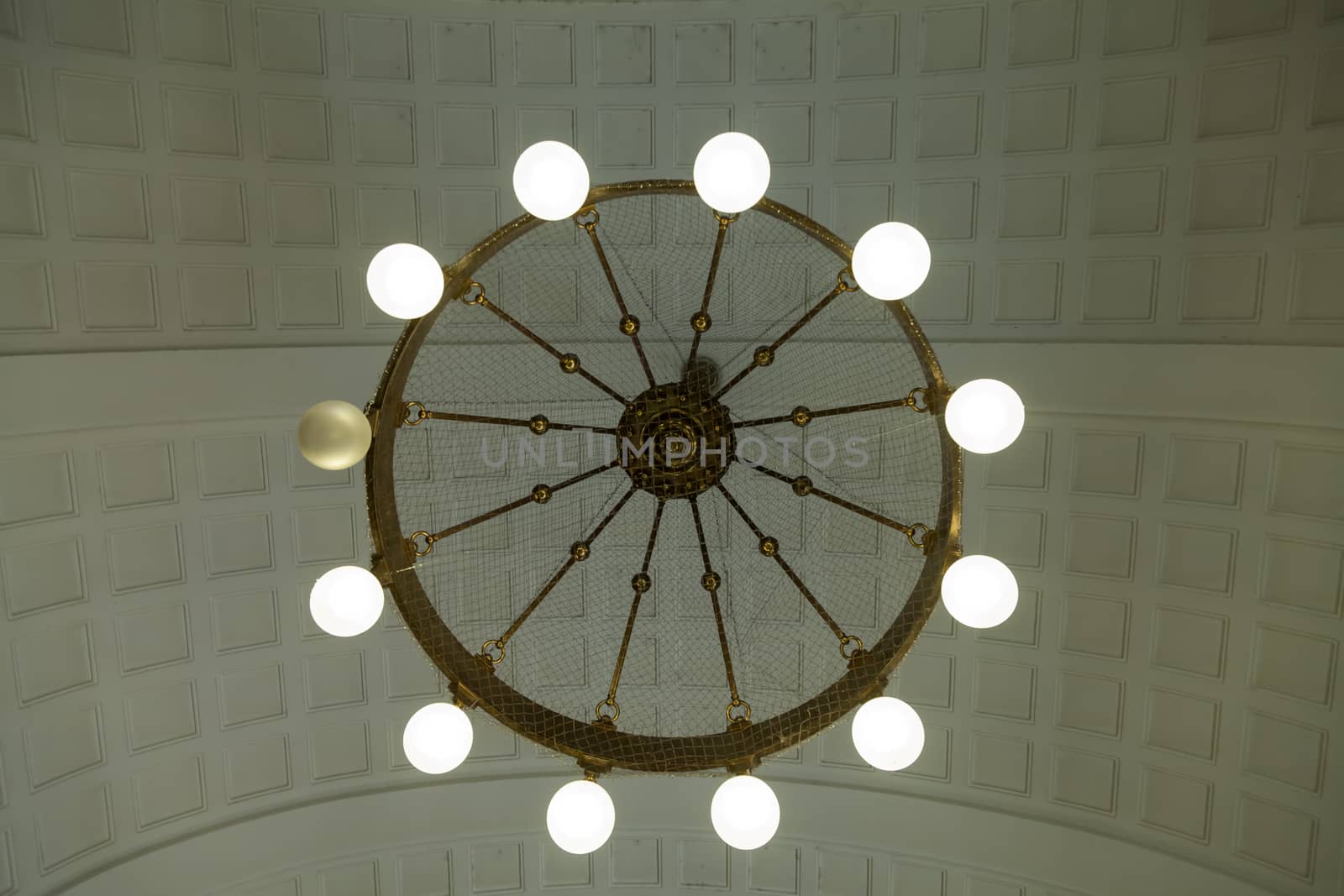 A circular lamp in a waiting hall with one broken