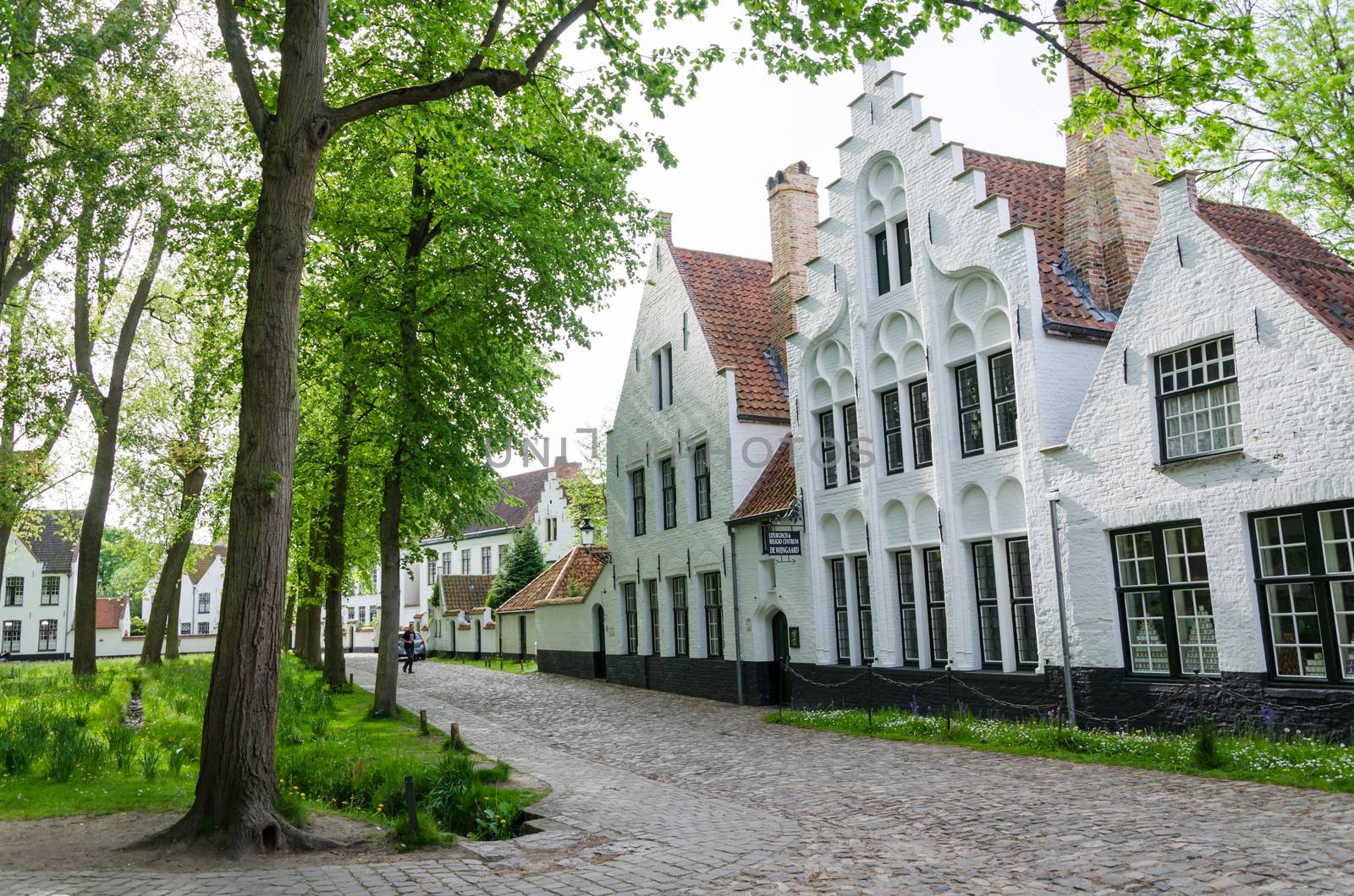 Bruges, Belgium - May 11, 2015: People visit White houses in the Beguinage in Bruges by siraanamwong
