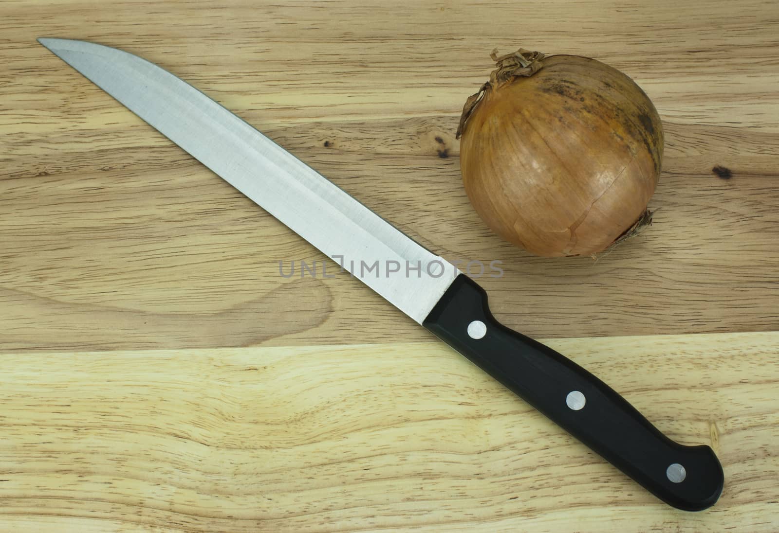 Onion on a wooden chopping board with knife