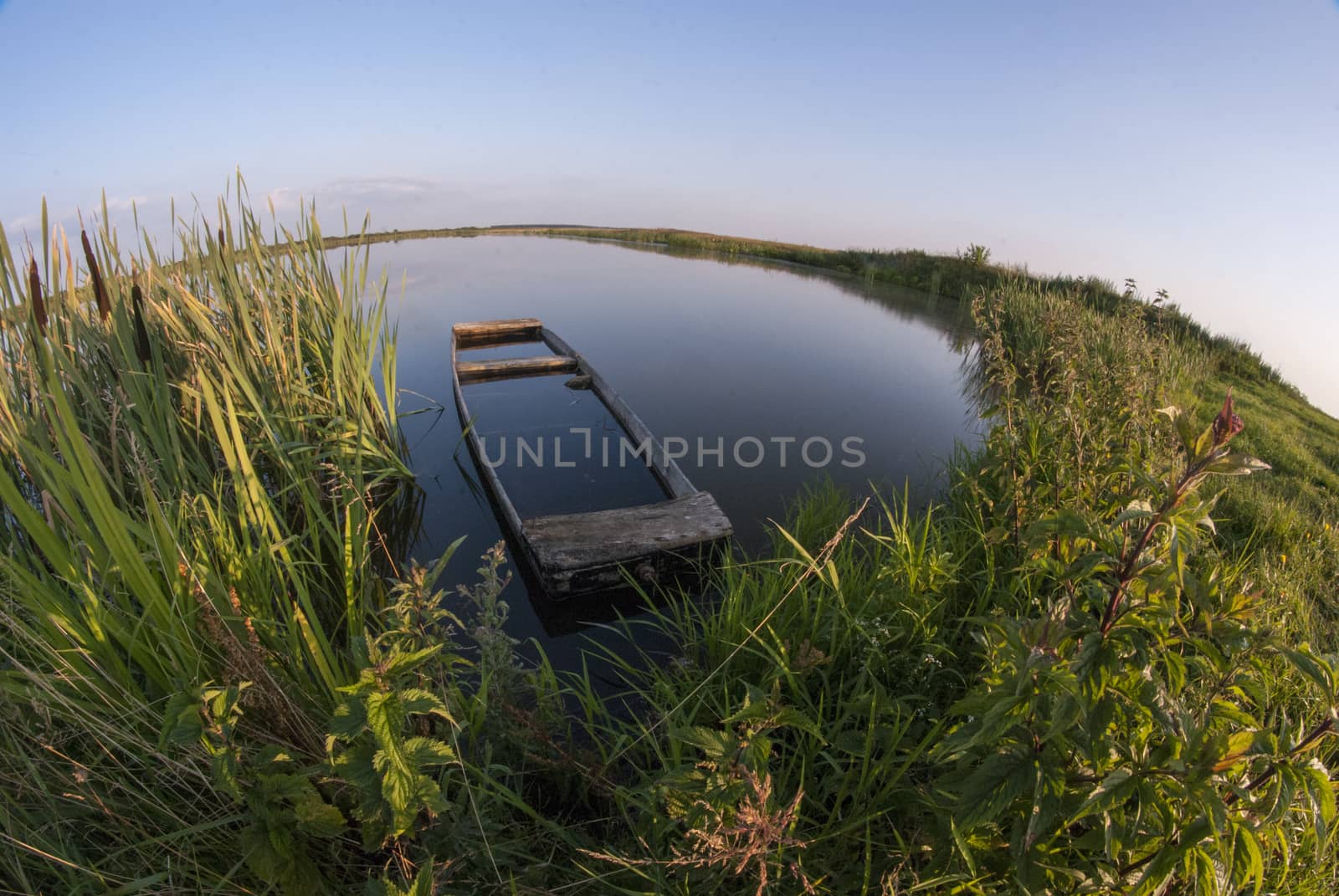 Old sunken wooden boat on the lake