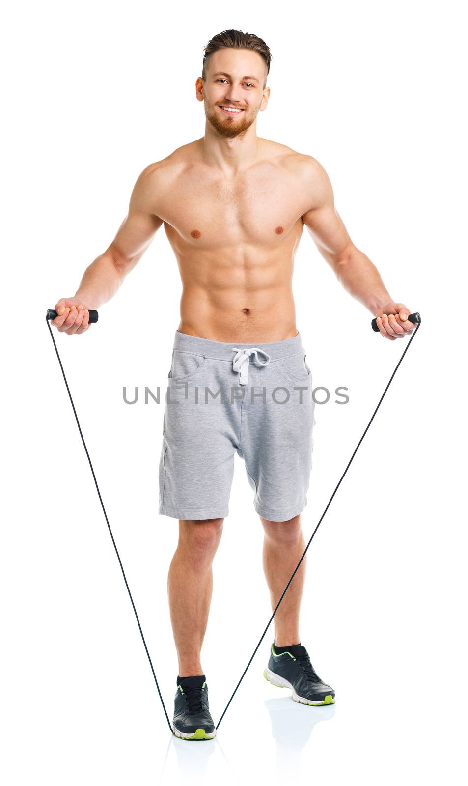 Athletic attractive man jumping on a rope on the white background