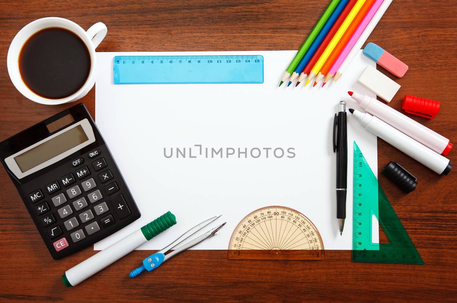 Desk with sheet of paper and stationery objects seen from above