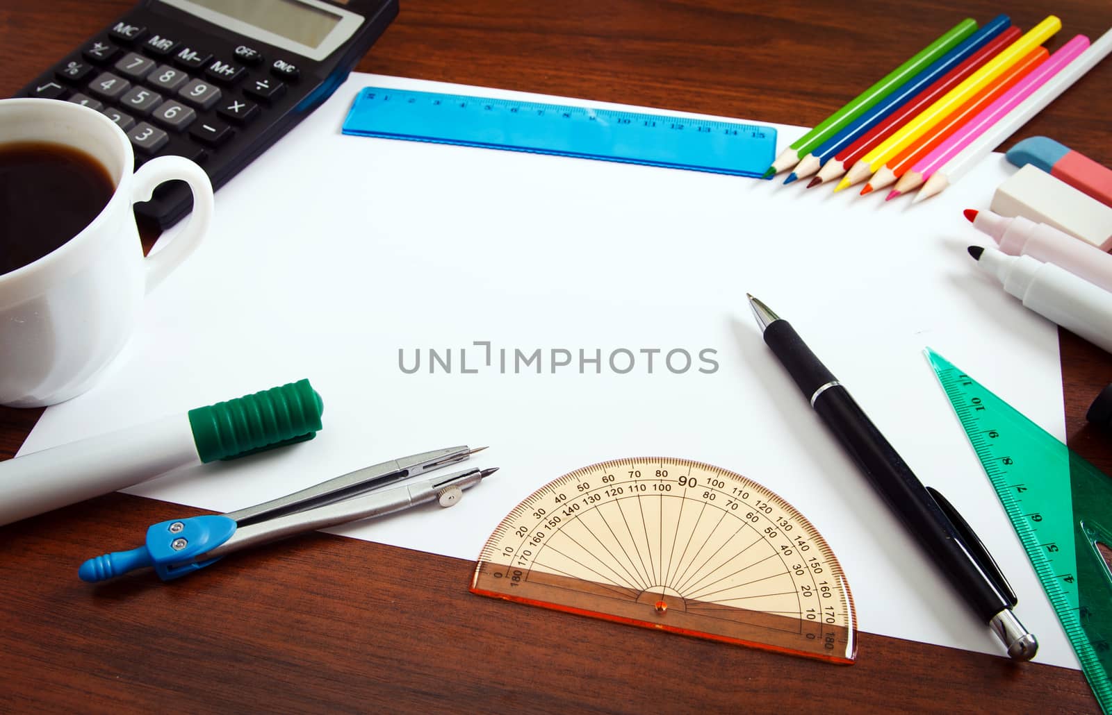 Desk with sheet of paper and stationery objects seen from above