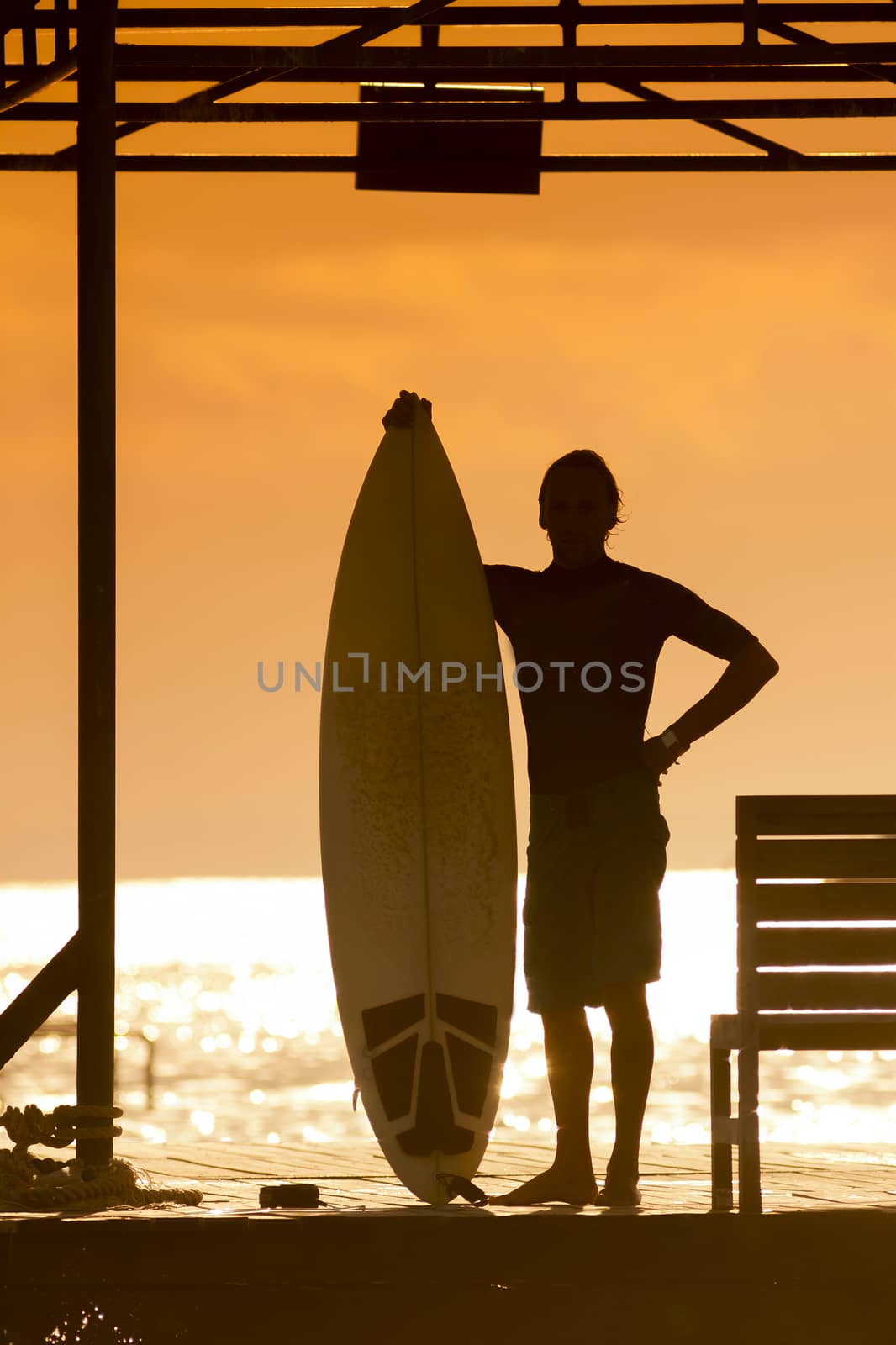 Surfer  with a surfboard at Sunset Tme, Bali, Indonesia
released