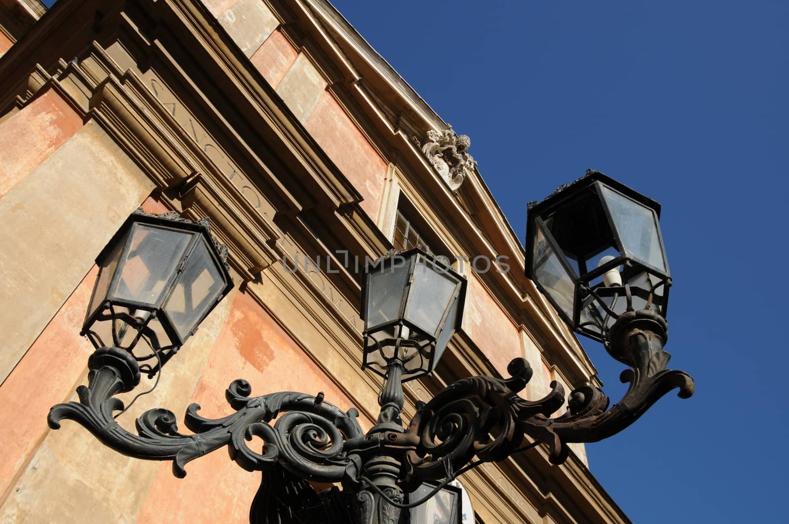 Perspective from the bottom of a street lamp in wrought iron in city