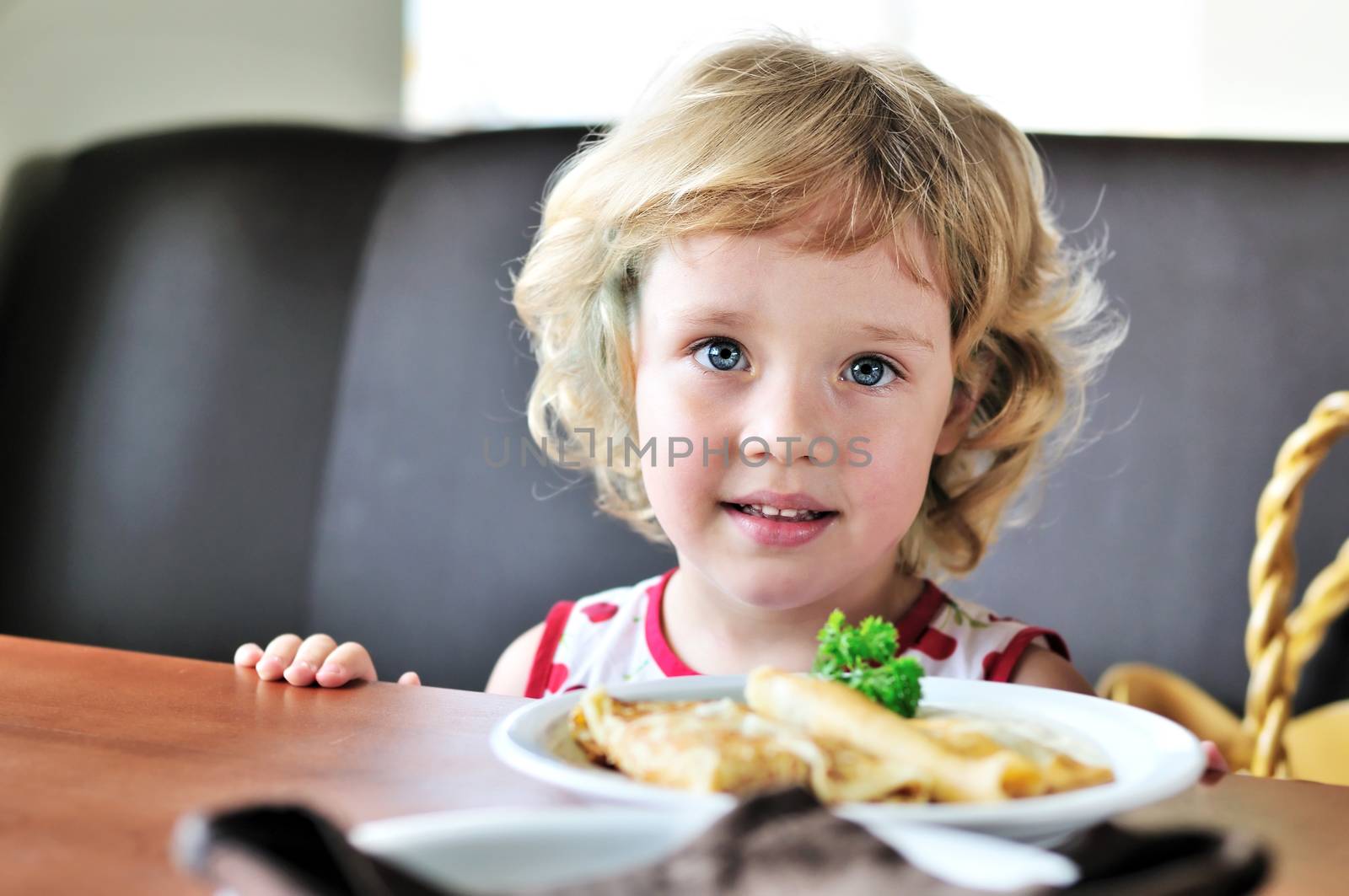 little blonde sweet girl eating  in cafe
