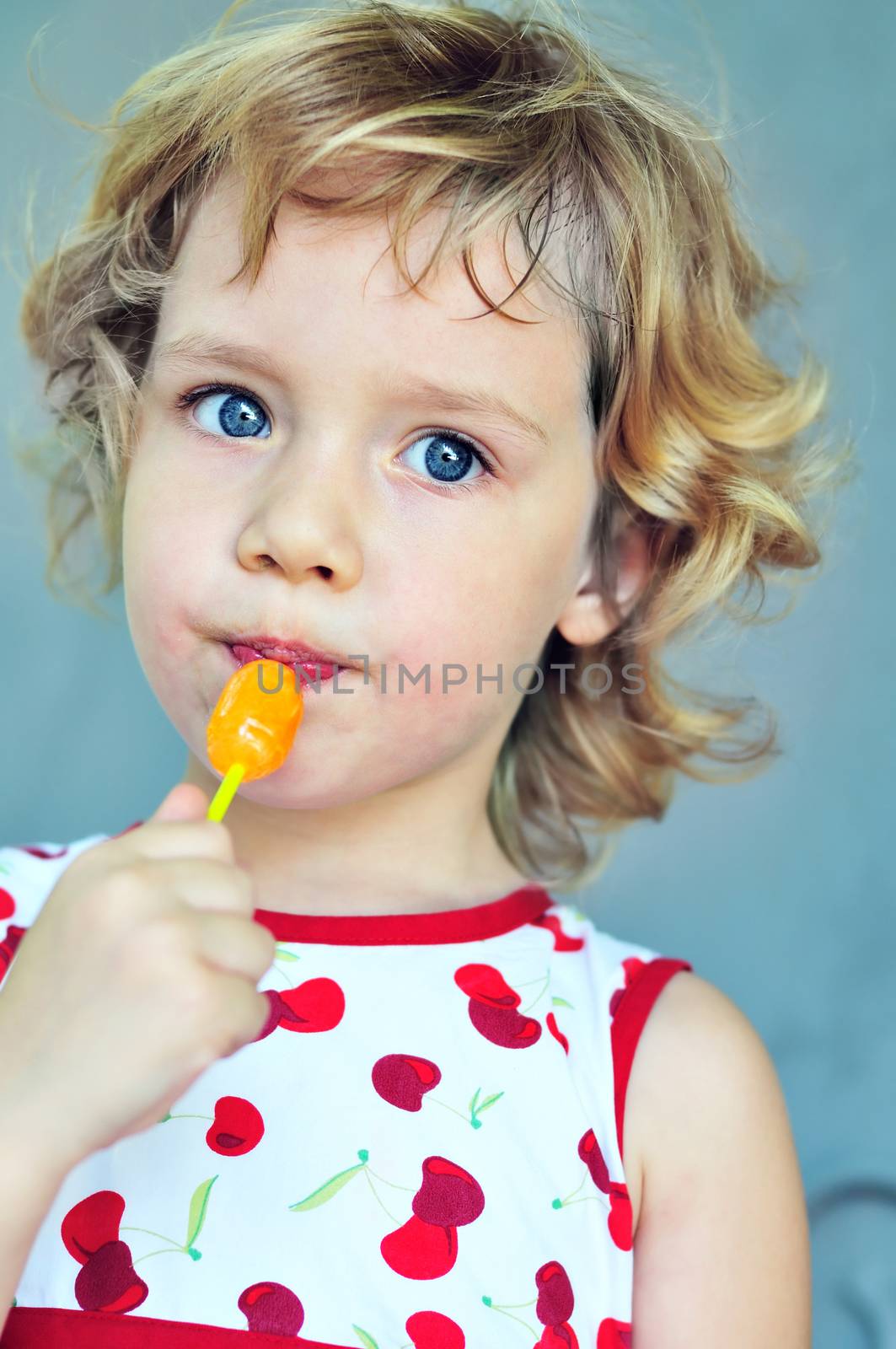 portrait of sweet blonde girl with lollipop 