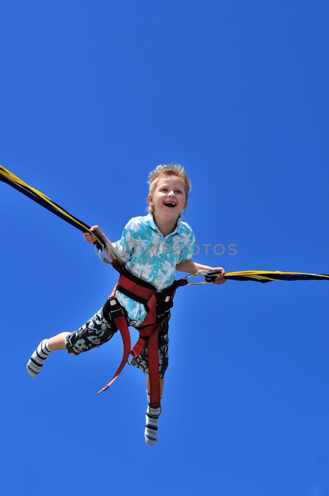 happy little boy flying over the blue sky 
