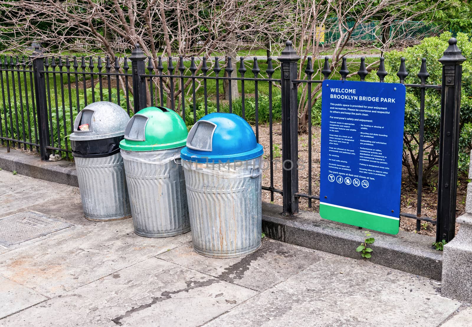 Trash Containers for Paper Cans and Garbage on footpath in Brooklyn Bridge Park in New York City.