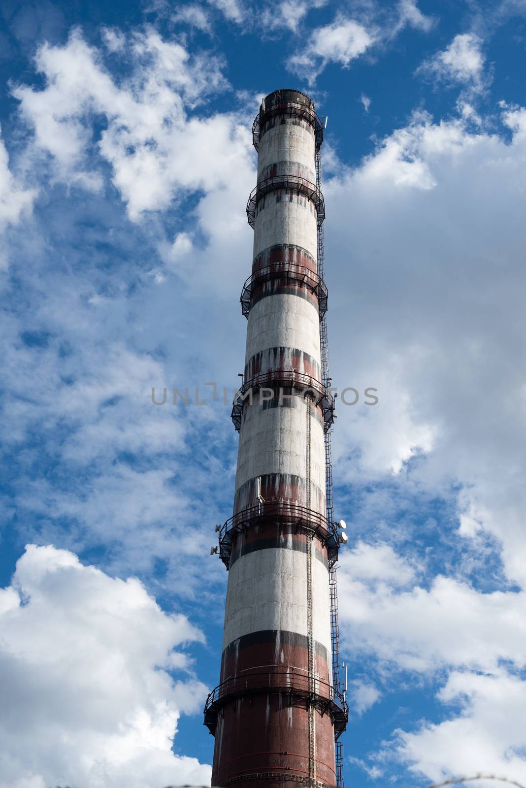 Smoke stack of the industrial plant against the cloudy sky