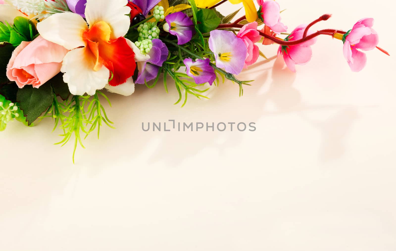 composition of artificial beautiful flowers on beige background