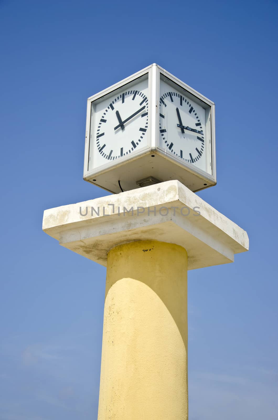 clock cube on vintage classic column and blue sky background, Greece