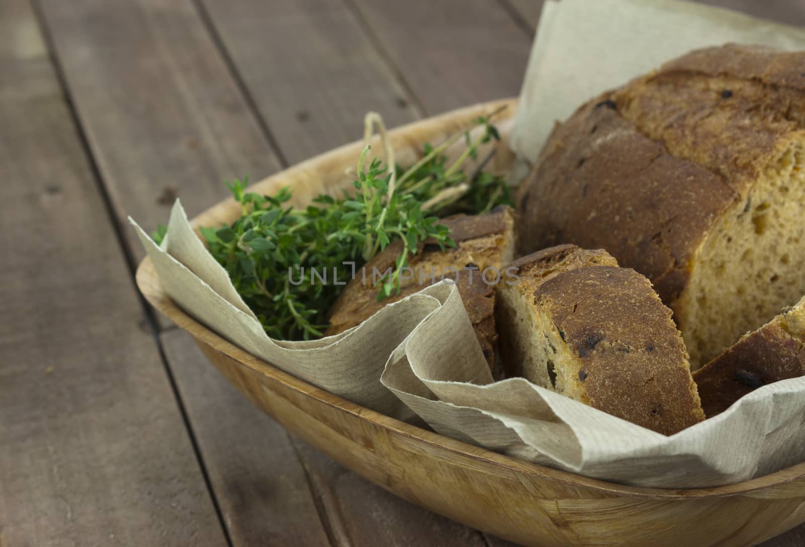 Loaf of wholemeal bread in a basket with brown paper