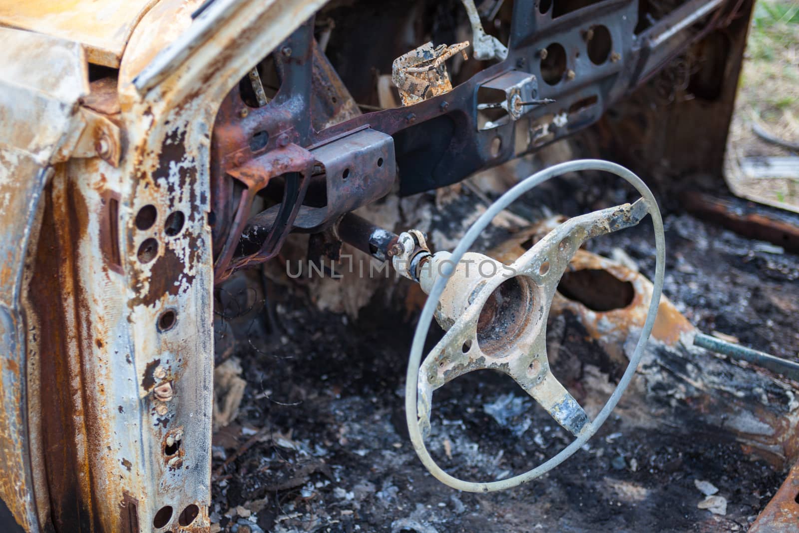 Burnt car interior with steering wheel after the accident