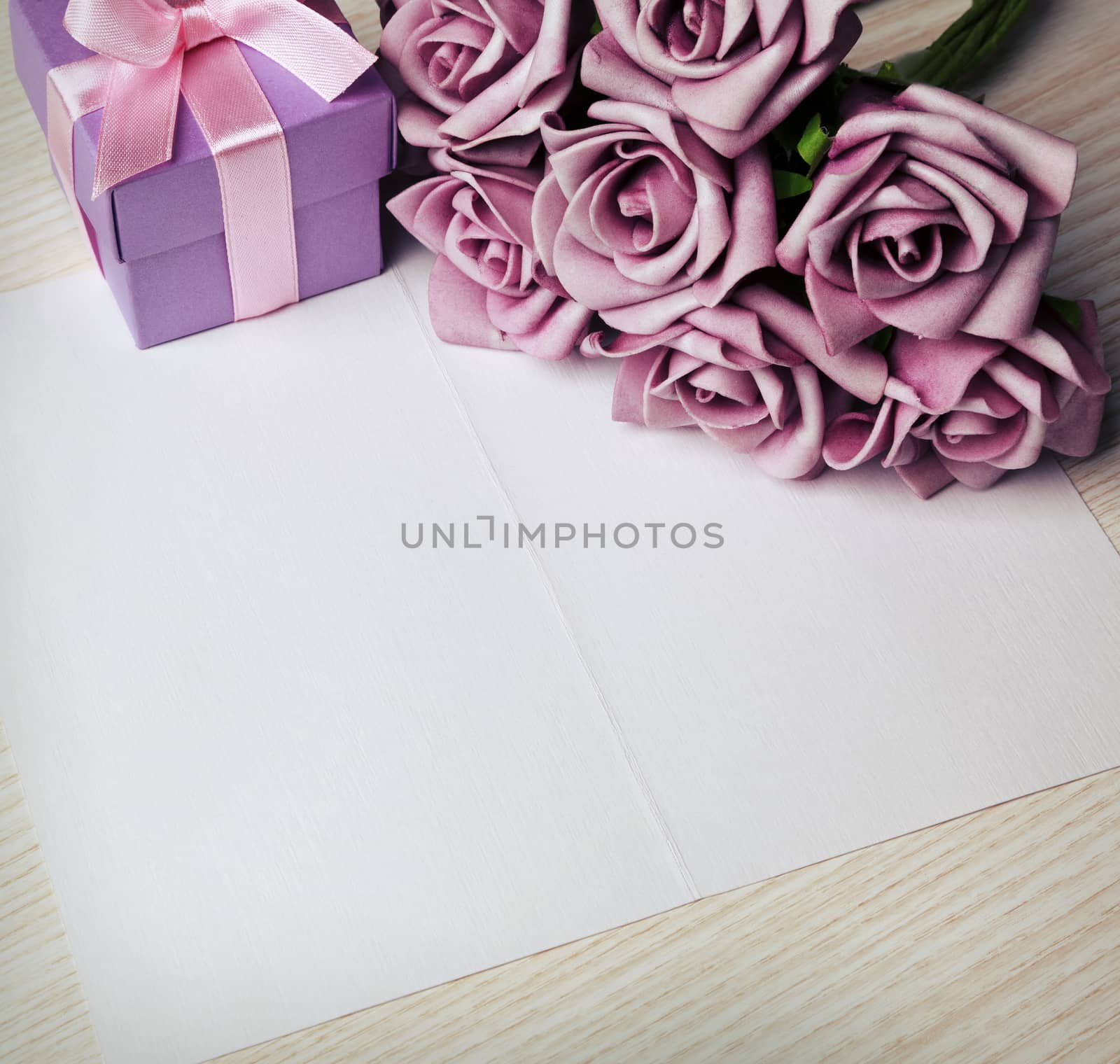 blank card with a pen, purple roses and purple gift box