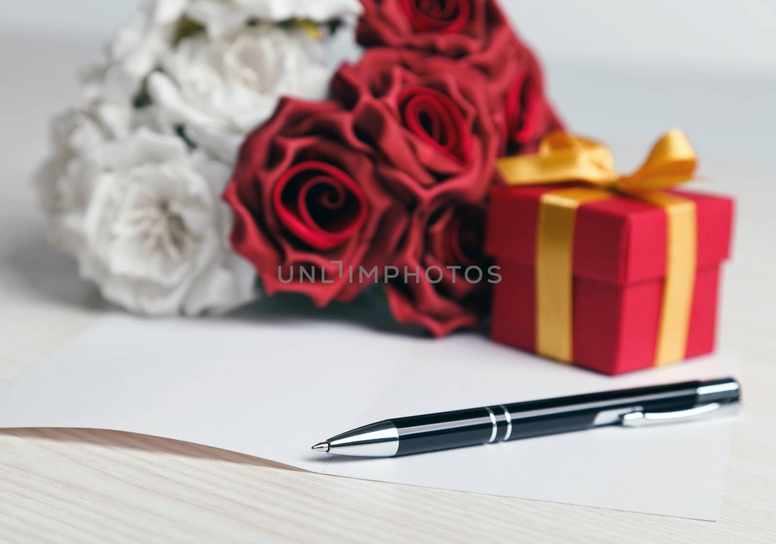 Greeting blank card with pen, rose and red box with yellow ribbon