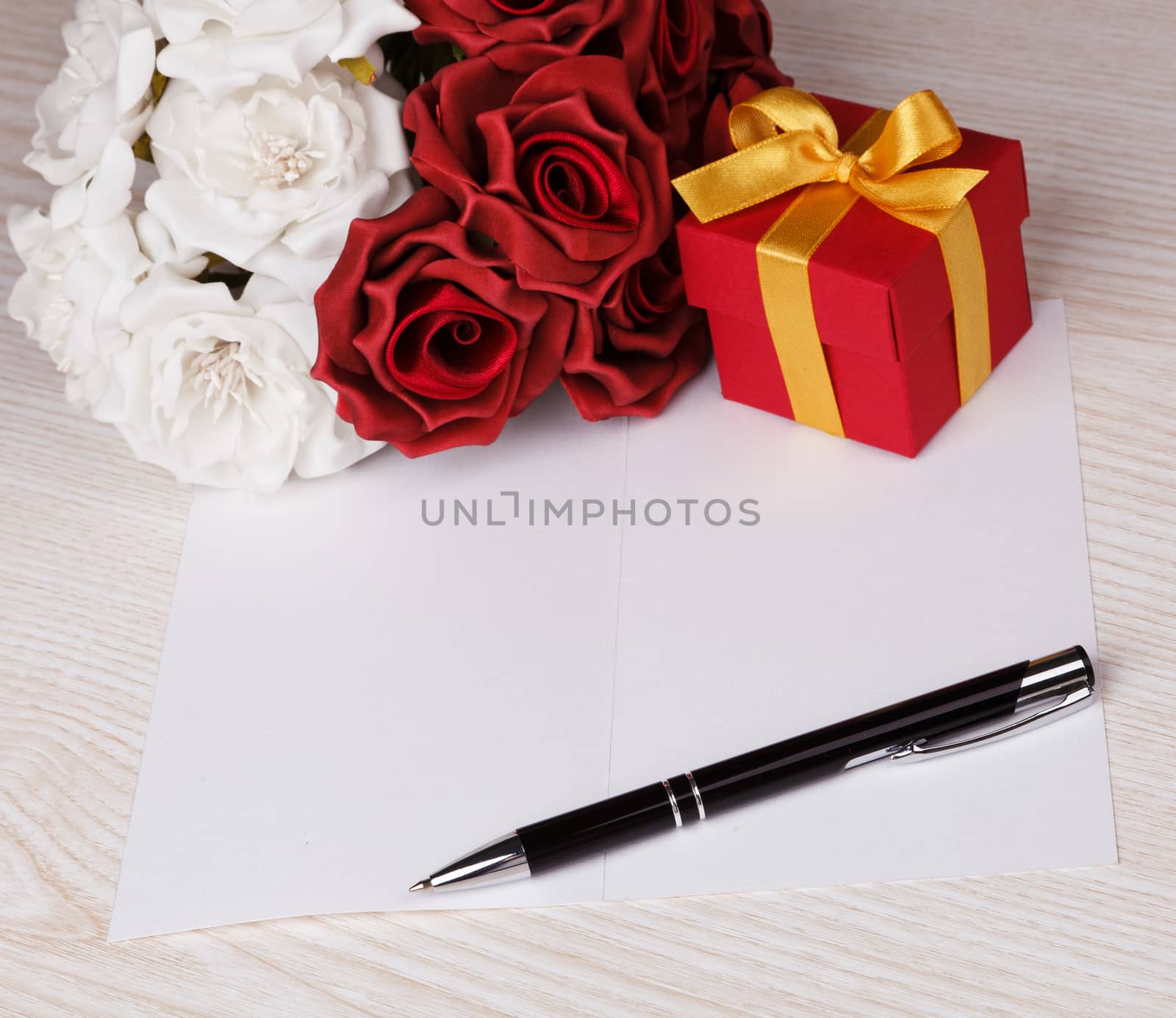 Greeting blank card with pen, roses and red box with yellow ribbon