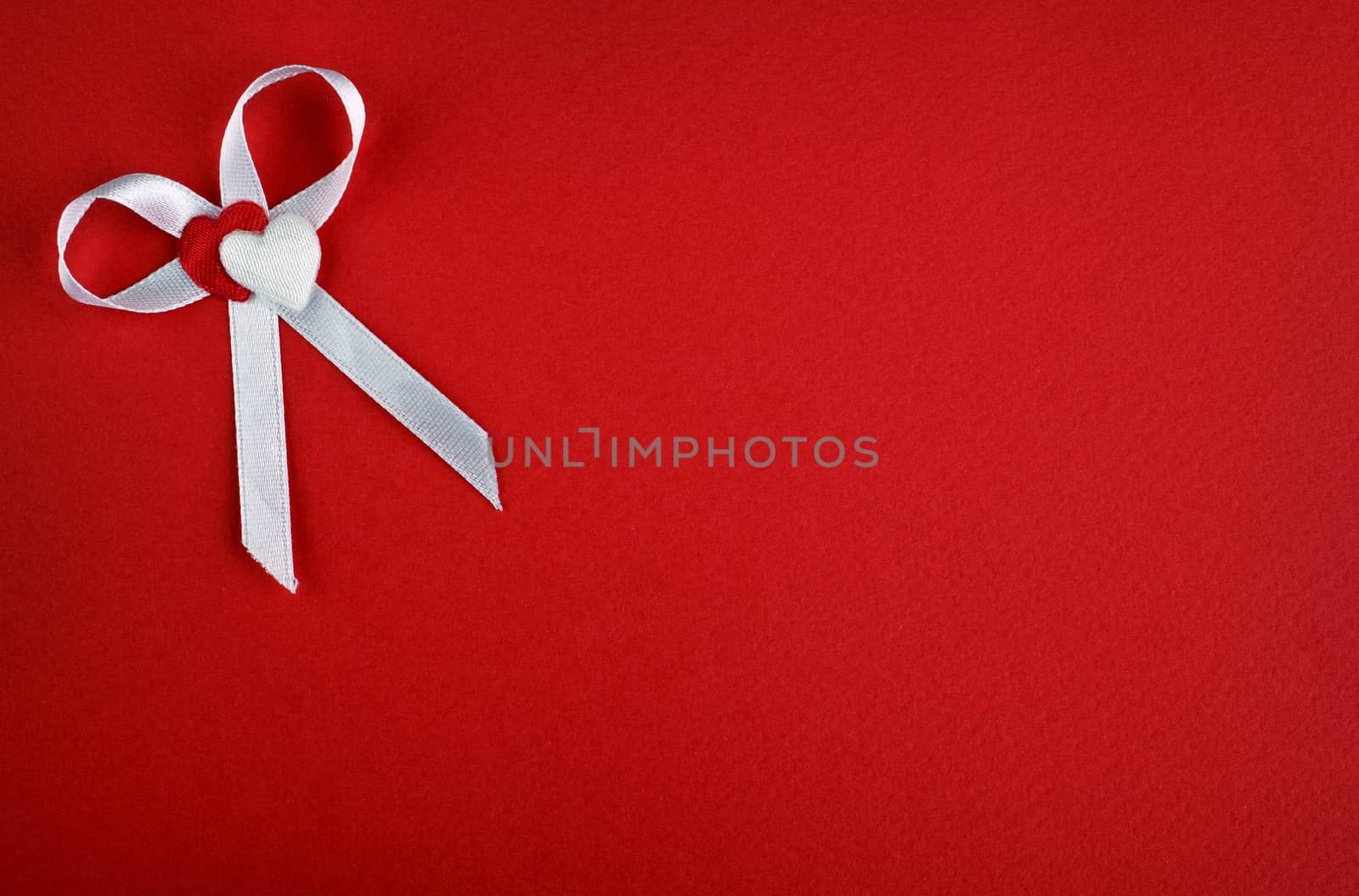 White bow with hearts on a red background