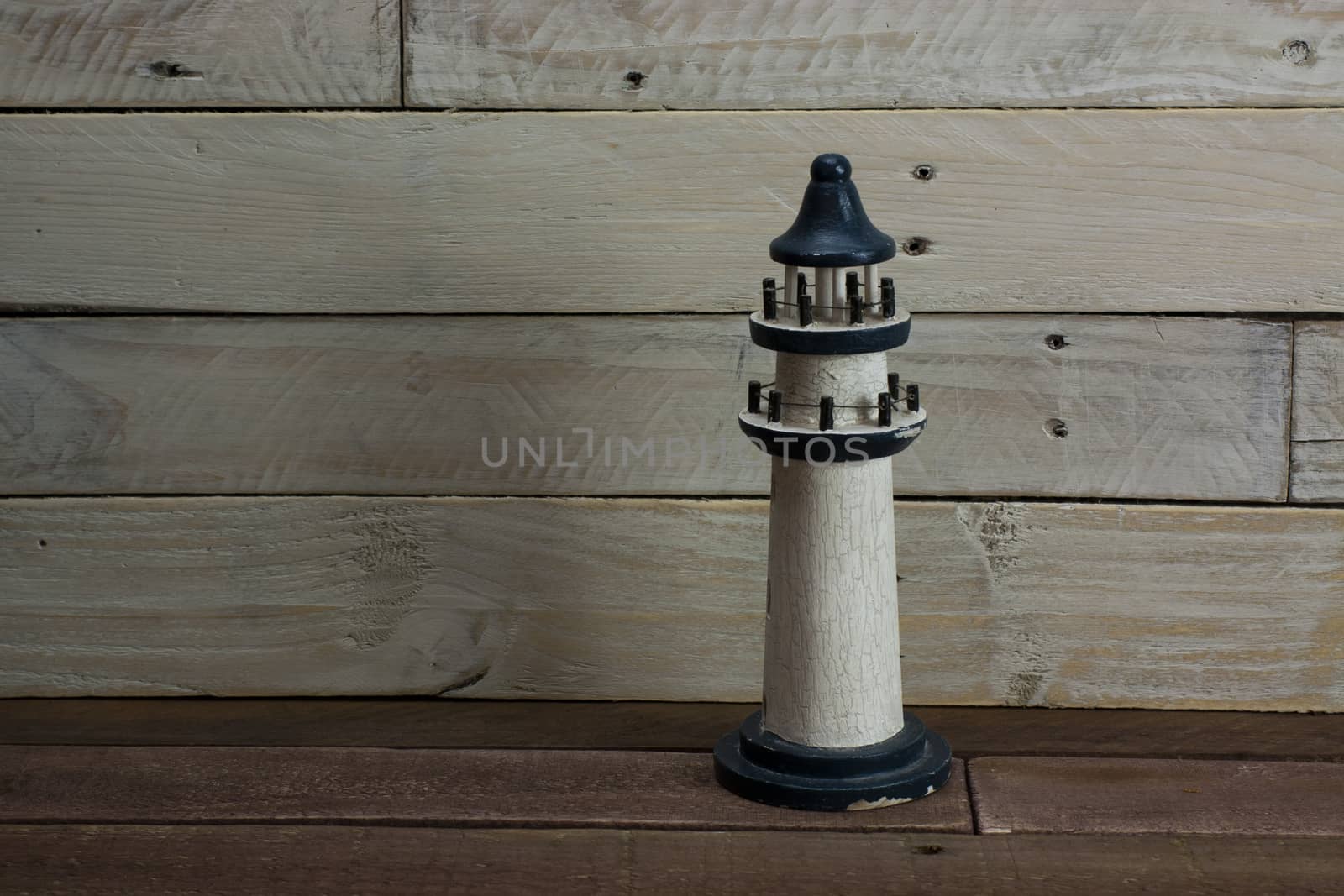 Lighthouse set against a worn wooden background