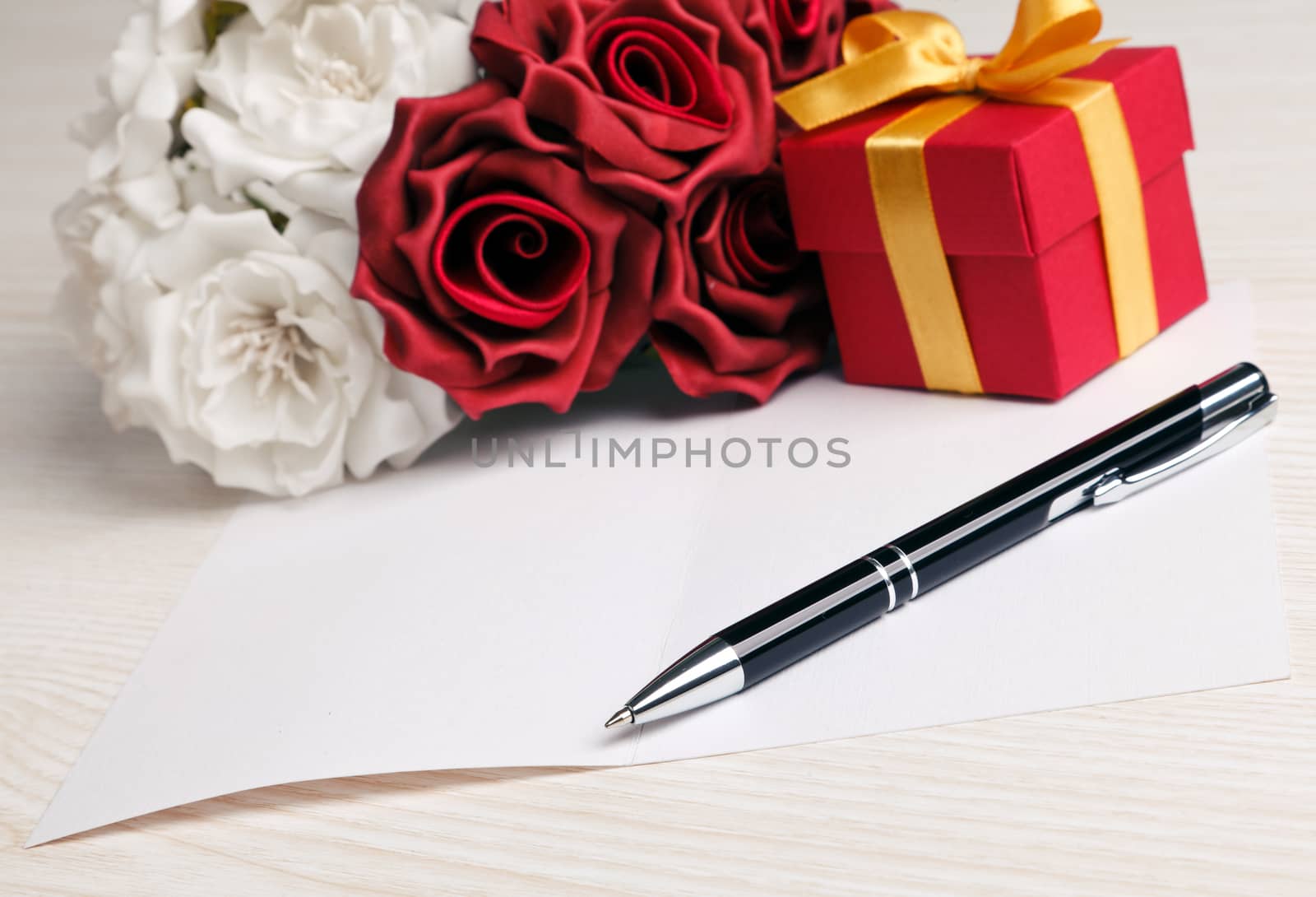 Greeting blank card with pen, rose and red box with yellow ribbon