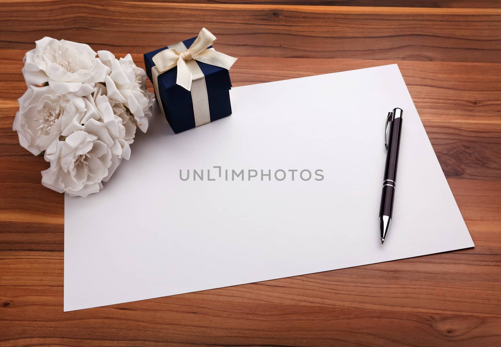 Greeting card with pen, white flowers and a blue gift box