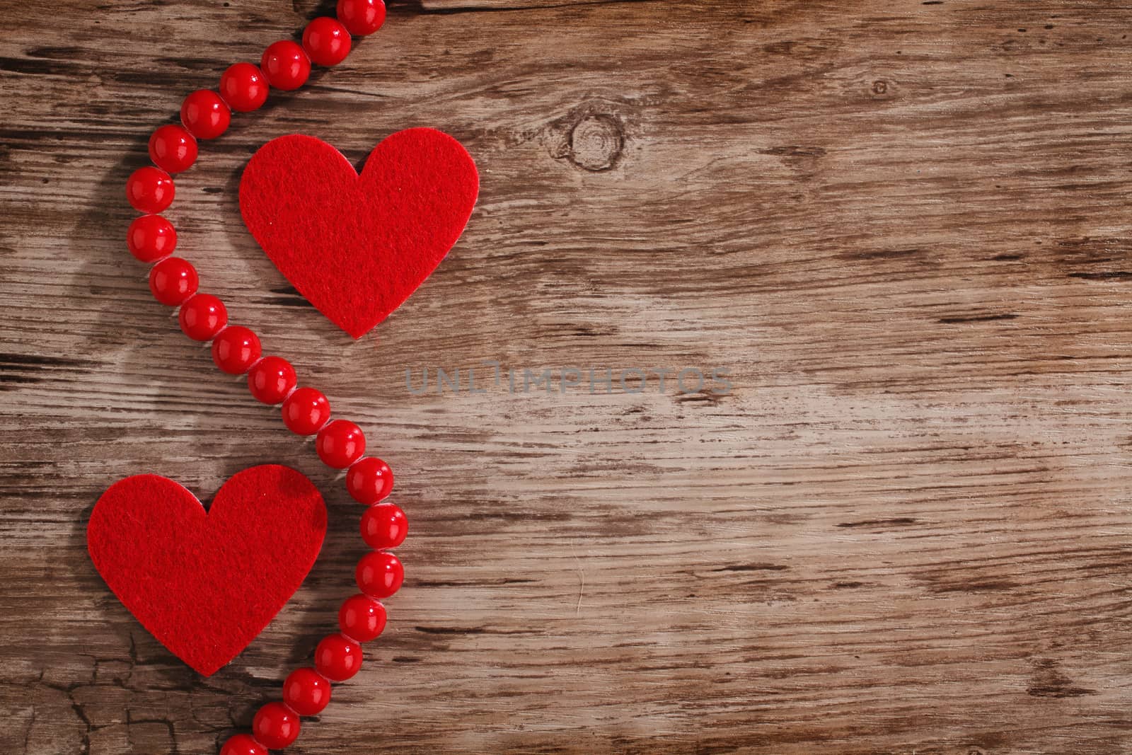 red heart with beads on a wooden background