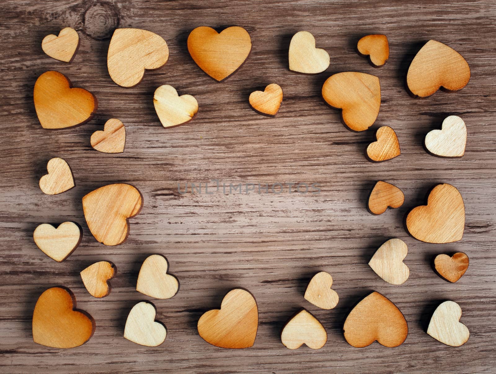 frame with hearts on a wooden background