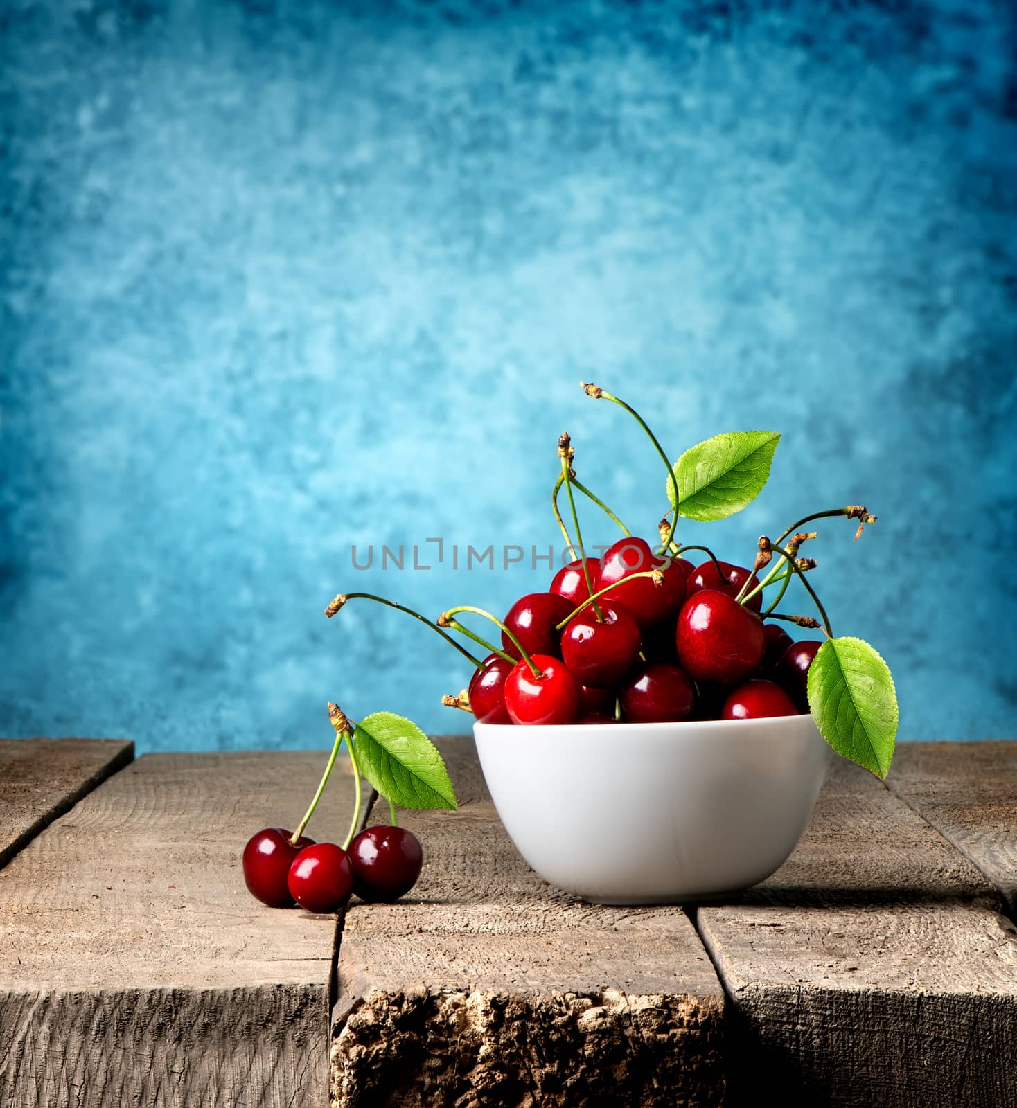 Red cherries in plate on a wooden table