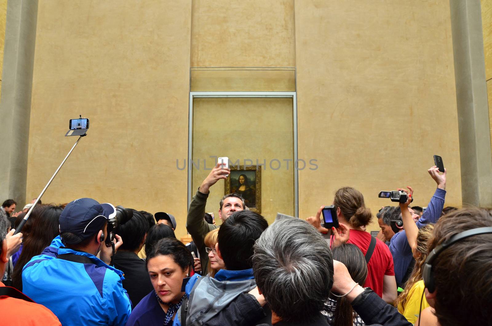 Paris, France - May 13, 2015: Visitors take photos of Leonardo DaVinci's "Mona Lisa" at the Louvre Museum on May 13, 2015 in Paris, France. The painting is one of the world's most famous.