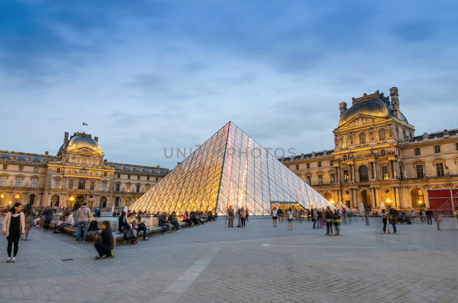 Paris, France - May 14, 2015: Tourist visit Louvre museum at dusk by siraanamwong