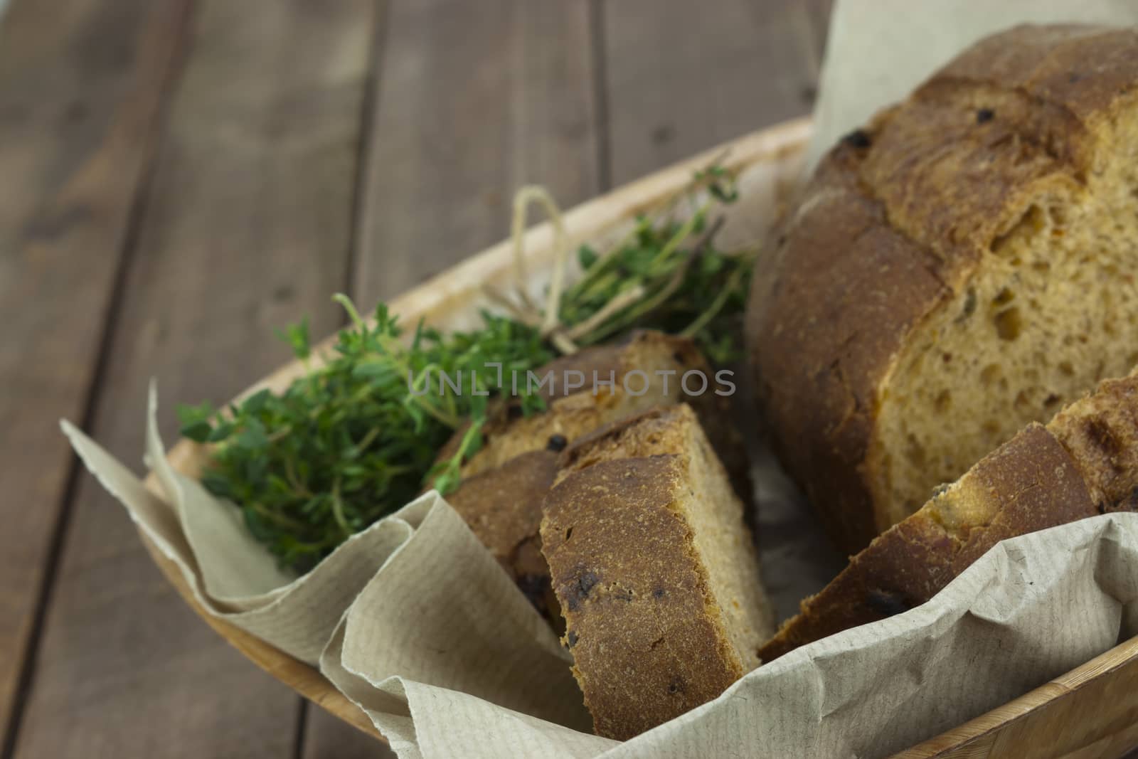 Loaf of wholemeal bread in a basket with brown paper