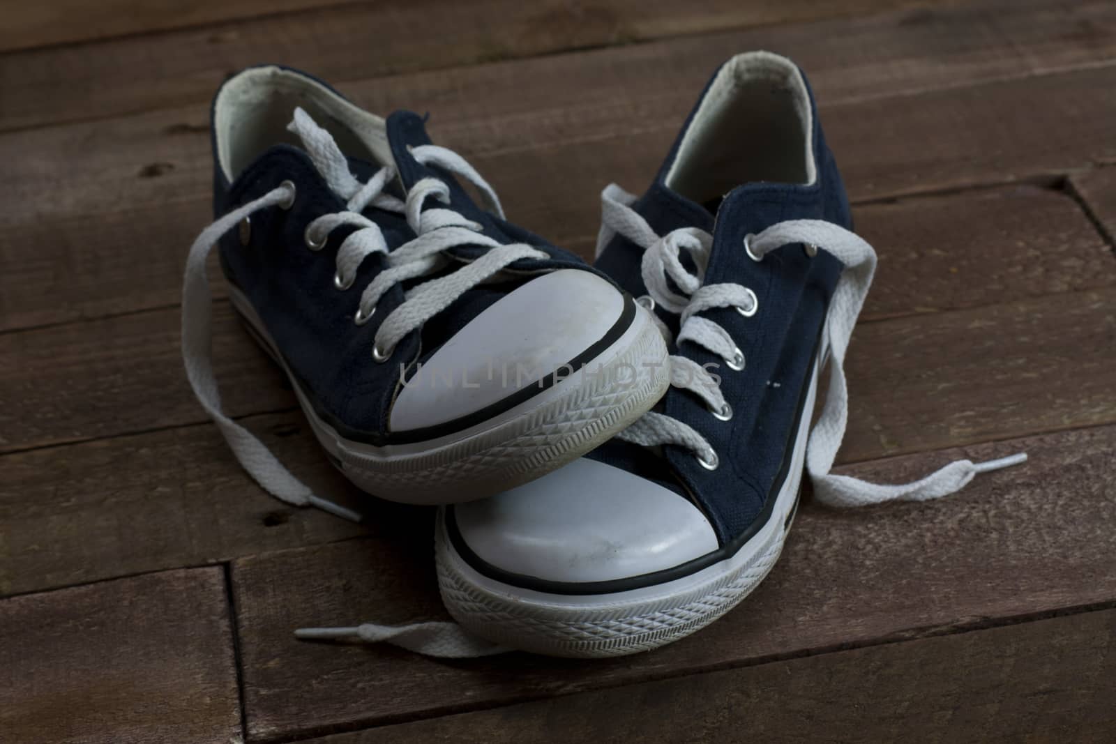 Old worn shoes left on a wooden floor