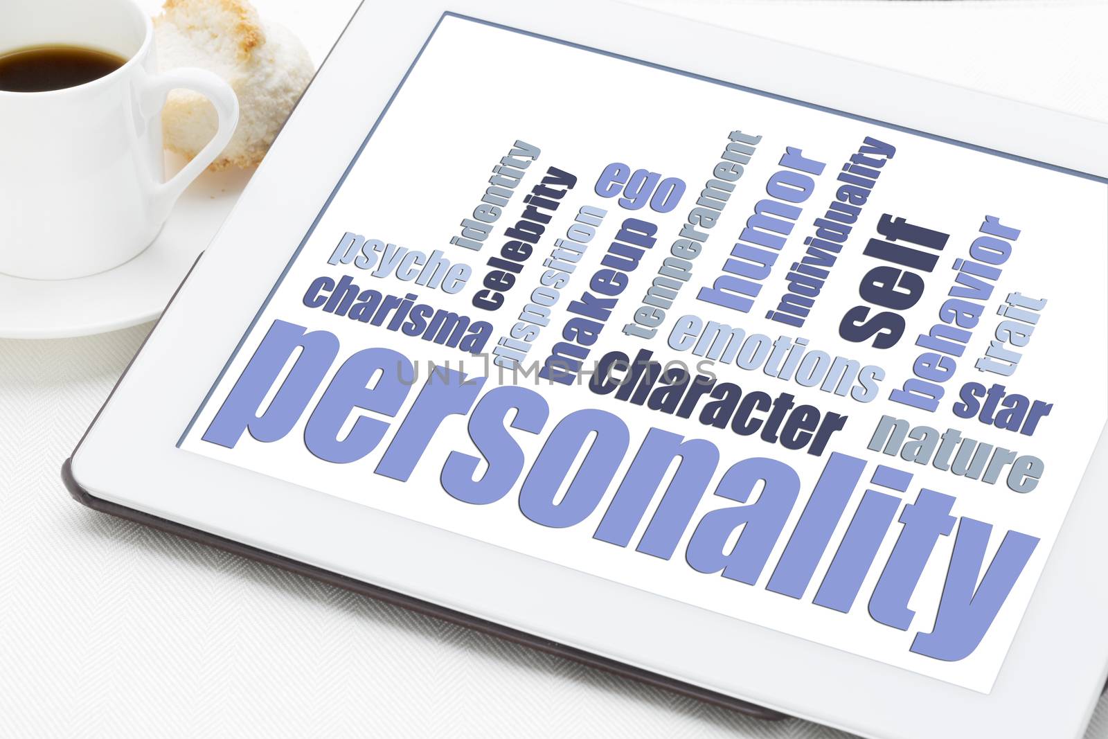 personality word cloud on a digital tablet with cup of coffee