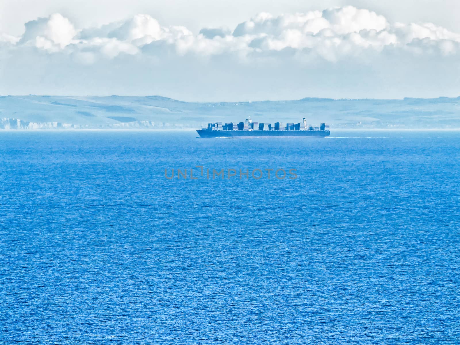 Ocean going container ship loaded with containers on deck sailing at sea